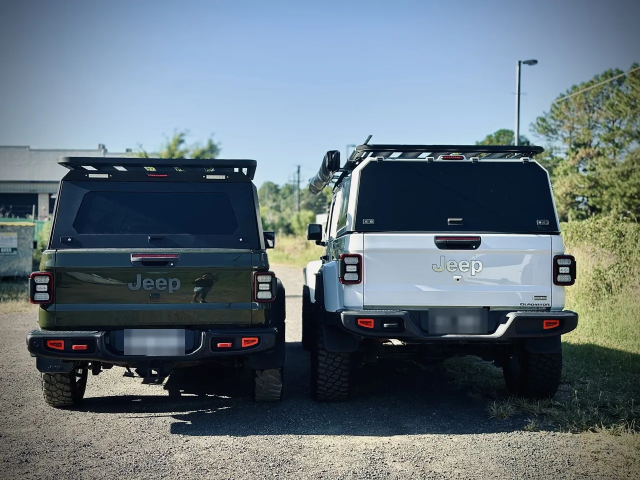 Two Jeep Gladiators fitted out with canopies and roof racks